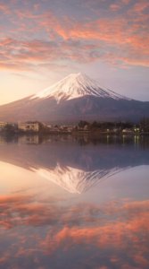 夕日で暗いオレンジ色に変化した雲に覆われる富士山を儚げに捉えた写真待受