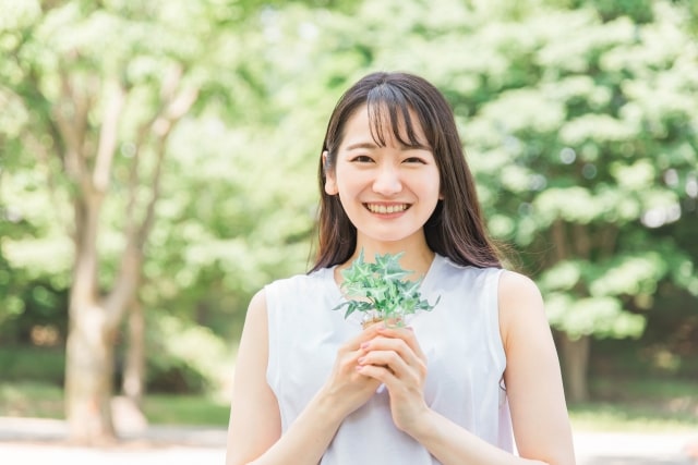 花を持ち笑顔でいる女性