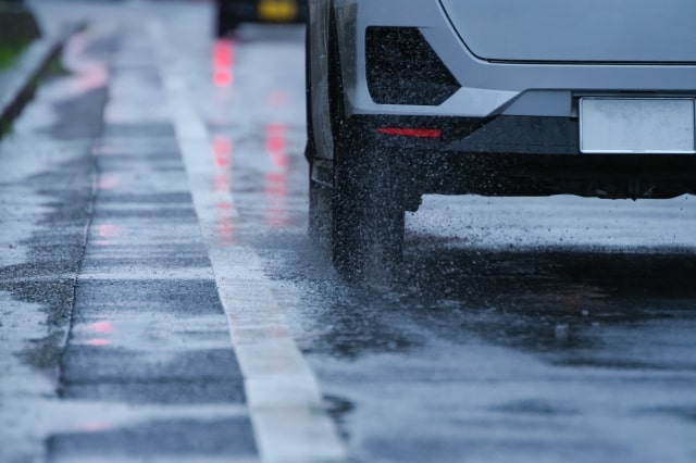 雨の道路で走る車