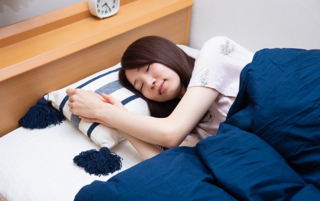 ベッドで眠っている女性