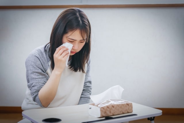 涙を流しそれをティッシュでふく女性