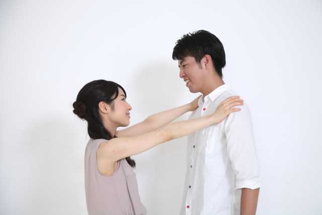 男性と女性が向き合いだきしめあおうとしている写真