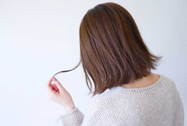 髪を数本ひっぱる女性