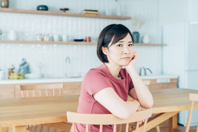 椅子に座り悩む女性