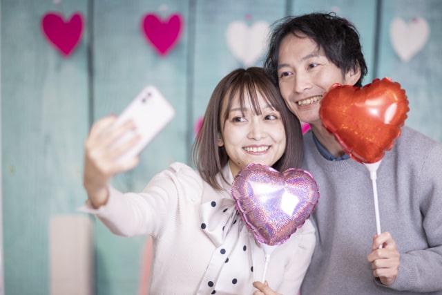 男女がスマホで写真を撮っている様子