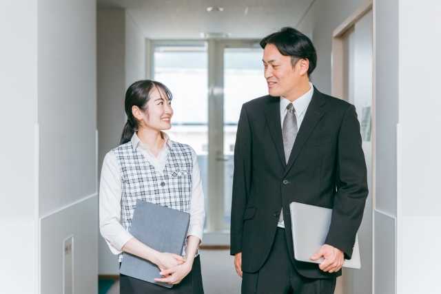 廊下で話す男性ビジネスマンと女性の事務員