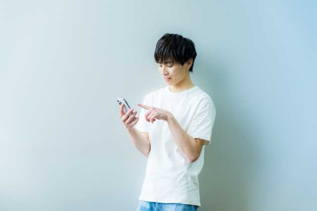 男性がスマホをタップしている様子