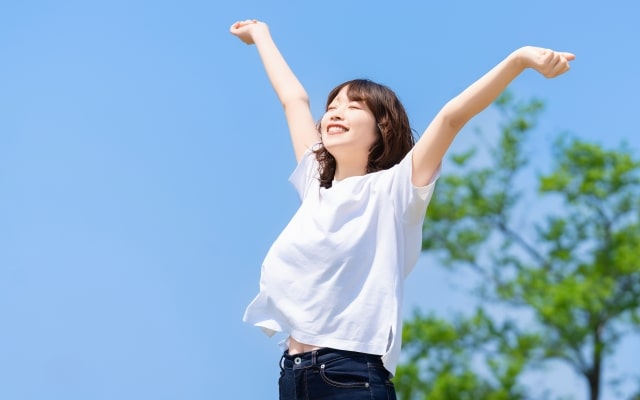 自然の環境で背伸びする女性