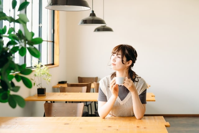 カフェでコーヒーを飲んでリラックスする女性